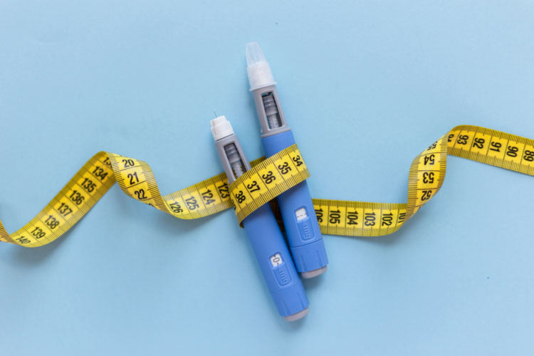 glp-1 dosing pens wrapped in measuring tape