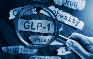 Magnifying glass focusing on GLP-1 semaglutide with obesity and weight loss drug terminology