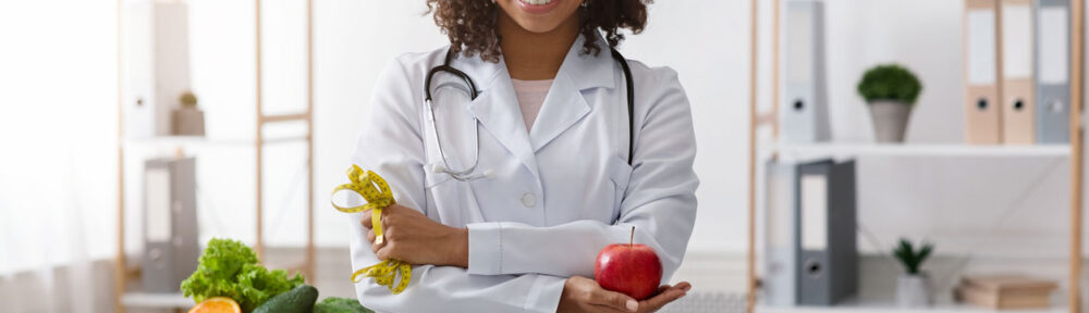 nutritionist holding an apple and a measuring tape